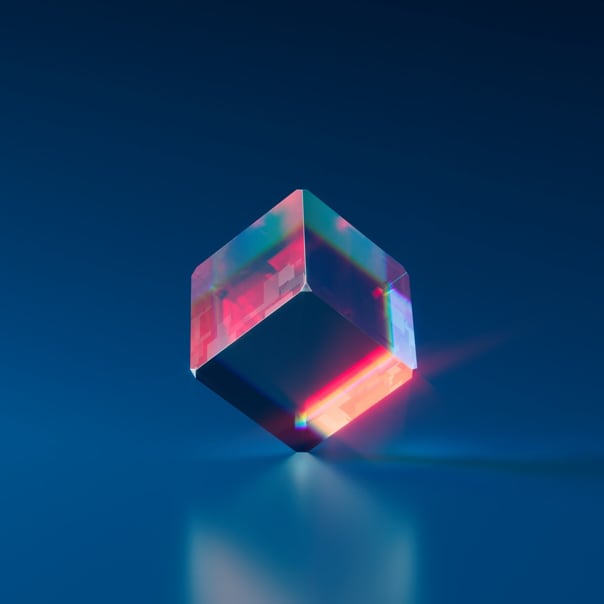 A glass cube with organge light shining through, set within a shiny blue background.